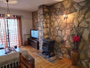 a living room with a stone wall with a stove at Family Apartments in Žabljak +58 photos