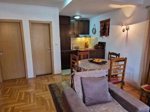 a living room with a table and a kitchen at Family Apartments in Žabljak