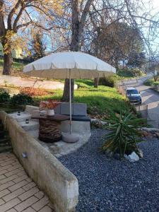 a table with a white umbrella in a park at D&P Cell Oneiro. in Kalavrita