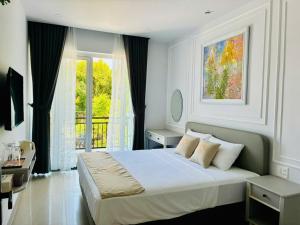 a bedroom with a large bed and a window at Happy House in Cam Lâm
