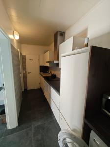 a kitchen with white cabinets and black counter tops at Zimmervermietung-Nbg in Nuremberg +5 photos