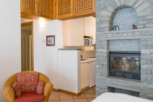 a living room with a fireplace and a chair at Residenza Del Sole in Gressoney-Saint-Jean