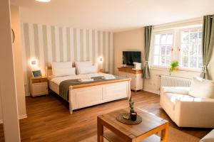 a bedroom with a bed and a living room at Restaurant & Pension Skipper Zingst in Zingst