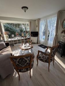 a living room with a couch and a table and chairs at Chalet Royal romantisch, uniek en volledig privé in Putten