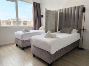 two beds in a room with a large window at Vibrant Raamsdonksveer, near Efteling & Biesbosch in Raamsdonksveer