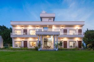 a large white house with a lighthouse on top of it at Corbett The Regnum Resort in Rāmnagar