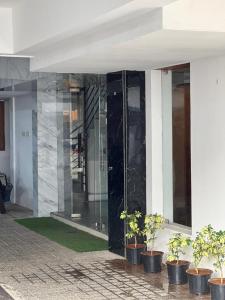 a glass entrance to a building with potted plants at Celestial Heights Kakkanad in Cochin