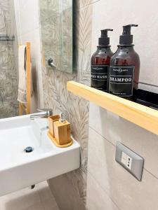 a bathroom with two shampoo bottles on a sink at Casa Lupoli in Caserta +16 photos