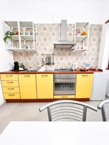 a kitchen with yellow cabinets and a stove top oven at Casa Lupoli in Caserta