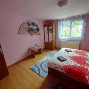 a bedroom with a bed with a red blanket at CASA IZA in Băile Herculane