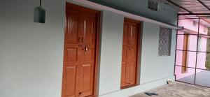 an empty room with two doors and a window at Sandeep Homes in Tehri-Garhwāl