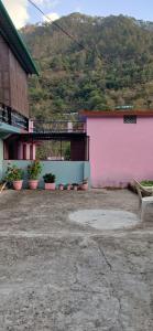 a pink building with potted plants on the side of it at Sandeep Homes in Tehri-Garhwāl