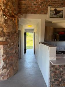 a hallway of a kitchen with a stone wall at DaisyRiver Cottage in Port Alfred