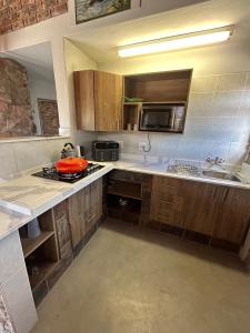a kitchen with a sink and a stove top oven at DaisyRiver Cottage in Port Alfred +8 photos