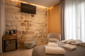 a bedroom with a bed and a stone wall at Le Quattro Perle in Monopoli