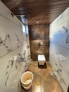 a bathroom with a toilet and a sink at Hotel Shree Balaji in Ujjain