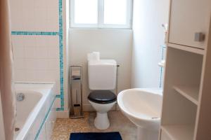 a bathroom with a toilet and a tub and a sink at Le Petit Marigny in Marigny-lʼÉglise +15 photos