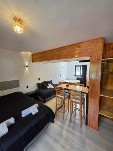 a bedroom with a bed and a table and a couch at Hotel Surprise Bariloche Centro con Desayuno y Restaurante in San Carlos de Bariloche