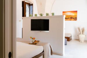 a living room with a tv on a wall at Tenuta del Barco WineRestaurant and Hospitality in Pulsano