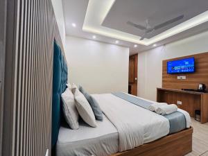 a bedroom with a bed with a tv on the wall at The Oakleaf Retreat - A Near Mall Road With Parking in Mussoorie