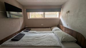 a small bedroom with two beds and a window at Maci-Ház in Orfű