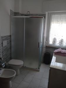 a bathroom with a shower and a toilet and a sink at La Torretta Sul Porto - Parcheggio gratuito in Livorno