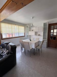 a kitchen and dining room with a table and chairs at Alojamiento caral in Laxe +8 photos