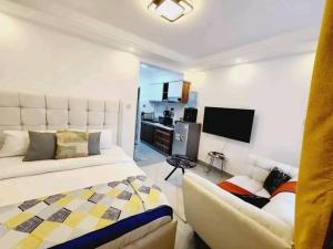 a living room with a bed and a couch and a tv at Lanson in Nairobi