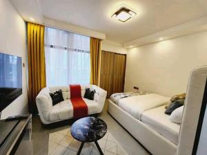 a hotel room with two beds and a couch at Lanson in Nairobi +1 photo