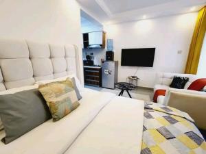 a living room with a white couch and a television at Lanson in Nairobi