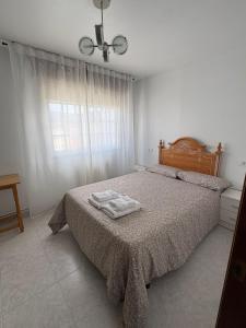 a bedroom with a bed with two towels on it at Alojamiento caral in Laxe