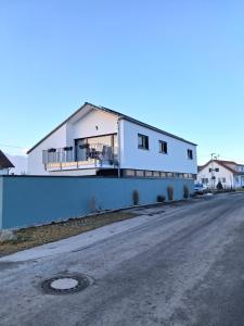 a white house with a balcony on the side of a road at Apartment Romi in Bad Waldsee