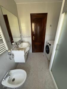 a bathroom with a sink and a toilet and a mirror at Alojamiento caral in Laxe