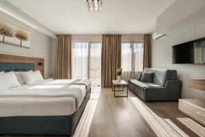 a bedroom with a bed and a chair and a television at Guest House Velik in Sandanski