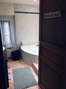 a bathroom with a bath tub and a door at Toulouse in Bazus