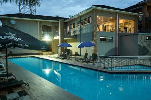 a swimming pool with chairs and umbrellas next to a building at Lifestyle Boutique Hotel in Lilongwe