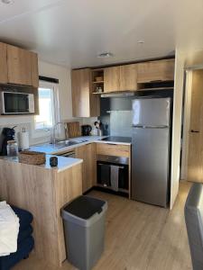 a kitchen with wooden cabinets and a stainless steel refrigerator at Finca Leberto in Renesse