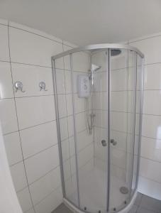a shower with a glass enclosure in a bathroom at Moodyscroft Homestay, NEC, BHX, Resorts world, HS2, JLR - Netflix in Birmingham