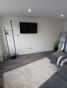a living room with a flat screen tv on the wall at Moodyscroft Homestay, NEC, BHX, Resorts world, HS2, JLR - Netflix in Birmingham