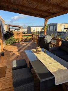 a patio with a table and chairs on a deck at Finca Leberto in Renesse