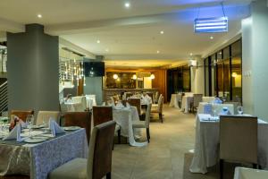 a dining room with tables and chairs with white tablecloths at Lifestyle Boutique Hotel in Lilongwe