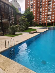 a swimming pool in a city with tall buildings at Dpto Nuñez in Buenos Aires