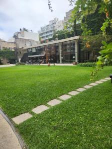 a building with a field of grass in front of it at Dpto Nuñez in Buenos Aires