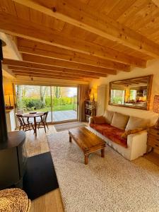 a living room with a couch and a table at Chalet Cormoran, face à l'océan in Fouesnant