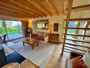 a living room with a couch and a table at Chalet Cormoran, face à l'océan in Fouesnant