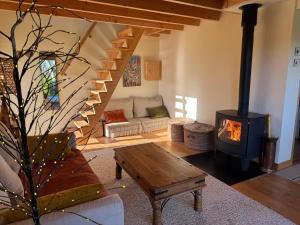 a living room with a wood stove in it at Chalet Cormoran, face à l'océan in Fouesnant