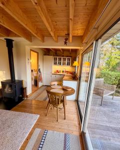 a kitchen and living room with a table and a stove at Chalet Cormoran, face à l'océan in Fouesnant +22 photos