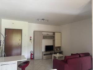 a living room with a red couch and a television at Home 14 in Tortoreto Lido