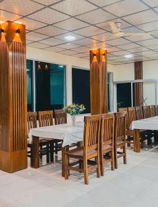 a dining room with a table and wooden chairs at Mountain Springs Resort in Bāndarban