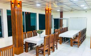 a dining room with white tables and wooden chairs at Mountain Springs Resort in Bāndarban